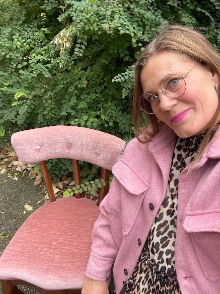 Annika Sundin med en rosa stol i naturen.