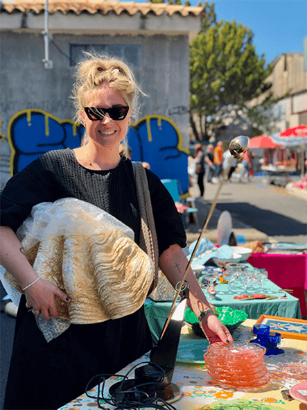 Frida Thofelt står och håller i ett stort snäckskal på en marknad.