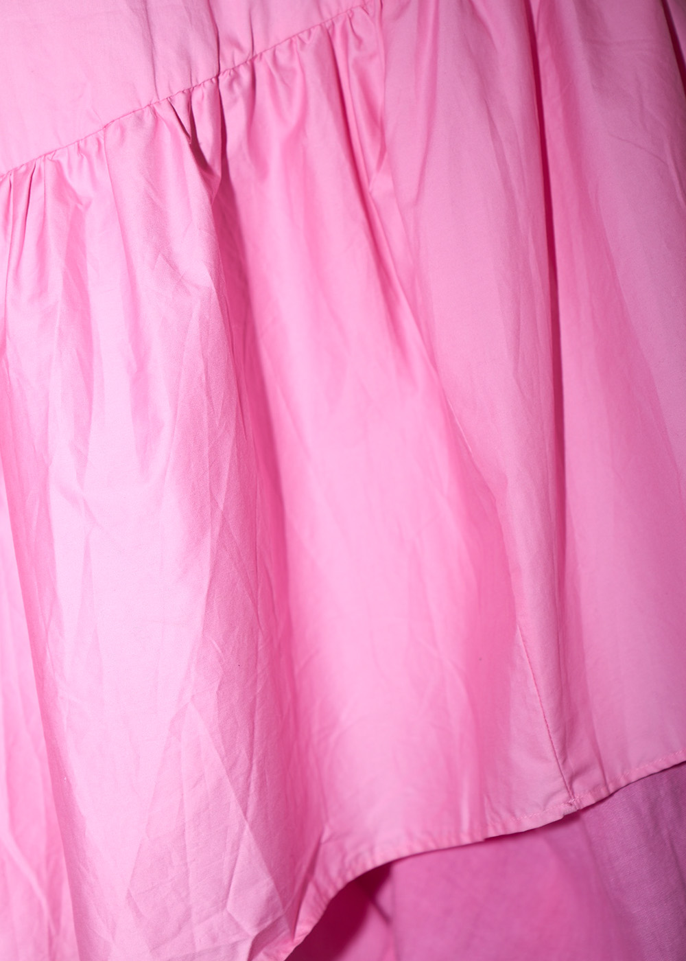 Rosa secondhandklänning inzoomad på böljande rosa tyg. Gå till sommarklänningar.